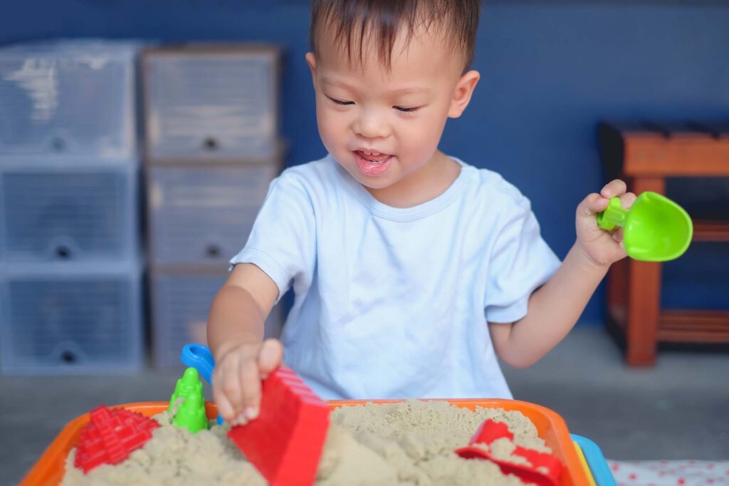 Cute smiling Asian 2 - 3 years old toddler boy playing with kine